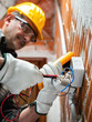 Electrician at work in an electrical system of a construction site. Construction industry.