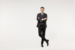 © ViDi Studio - Full length young successful employee business corporate lawyer man 20s wearing classic formal black grey suit shirt tie work in office hold hands crossed folded isolated on white background studio.