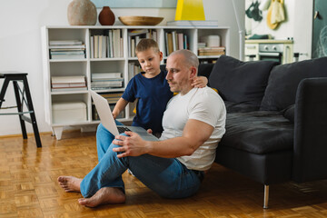 Wall Mural - father and son using computer at home