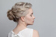 Gentle blonde model woman with updo hairstyle on white background