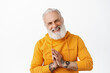 Thank you. Happy senior man with tattoos show namaste grateful gesture, bowing and thanking for help, looking pleased and smiling, express gratitude, standing over white background