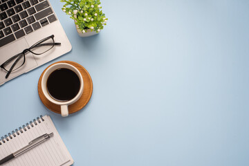 Top view of a blue desk with other work equipment coffee mug. Copy space.