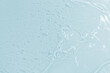 © Alina - Abstract cosmetic background from transparent gel or antiseptic, hyaluron on blue background