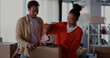 © Fractal Pictures - African american young beautiful couple moving house, packaging their items and taping carton boxes. Preparation. Empty home.