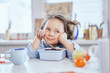 © boytsov - The girl is having dinner at the table. Small cute schoolgirl having lunch. Eating using fork from lunch box. Tasty eating. High quality image
