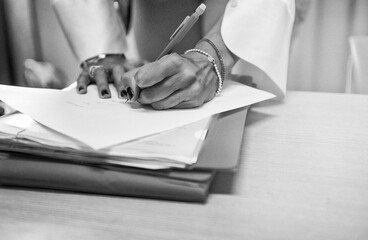 Hand of a woman signing documents in the office