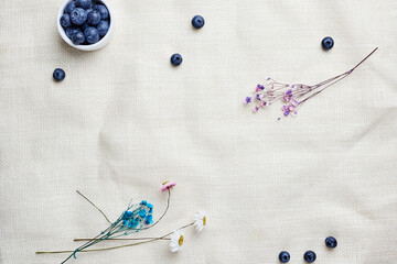 background rough linen fabric with blueberries and dried flowers