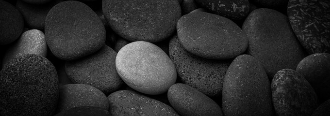 Wall Mural - Dark black abstract smooth round pebbles sea texture background