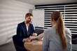 © Drazen - Businessman talking about report data while going through paperwork with female coworker in the office.