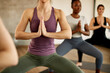 © Drazen - Unrecognizable athletic woman with hands clasped exercising on Yoga class in health club.