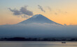 Late afternoon view of a partially fog-shrouded Mount Fuji and Lake Kawaguchi under a colorful sunset sky