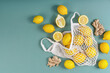 © Вадим Каштанов - Healthy products in the form of lemons and ginger roots on string bag, on simple light green background with copy space, the concept of eco-friendly and healthy lifestyle.