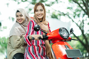 happy muslim friend riding motorcycle scooter together