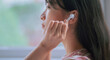 © Timeimage - Young Asian woman using wireless earphones to listen music