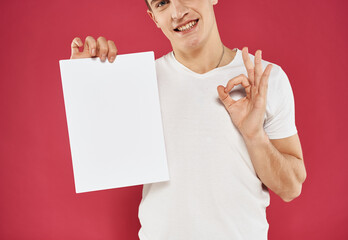 Man with flyer in hand and red background positive gesture model