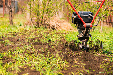 Wall Mural - plowing machine working with soil at springtime farmland