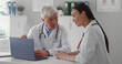 © TommyStockProject - Team of doctors working together in hospital checking patient test results on laptop
