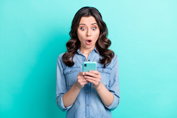 Wall Mural - photo of young girl amazed shocked look read browse fake news cellphone isolated over turquoise colo
