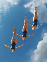 three women jump into the water from a height 