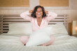 © TheVisualsYouNeed - morning portrait of young beautiful and happy African American woman in pajamas relaxed and cheerful on bed awake in the morning in positive mood smiling