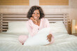 © TheVisualsYouNeed - morning portrait of young beautiful and happy afro American woman in pajamas relaxed and cheerful on bed awake in the morning in positive mood smiling