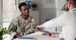 Military doctor studying x-ray consulting african soldier patient