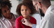 © nimito - Doctor examining little african girl by stethoscope in clinic office
