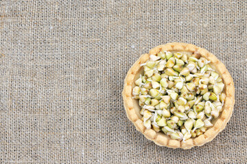 Tartlet with sprouted green buckwheat on a linen background.Healthy food. Vegan food. Nature vitamins. Super food. Copy spase