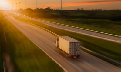 Cargo truck with heavy container speed on high way road to delivery logistic business with sun sky background