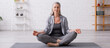 © LIGHTFIELD STUDIOS - mature woman with grey hair sitting in lotus pose on yoga mat, banner