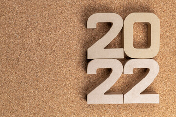 Year 2022 in cardboard figures on a cork background.