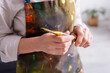 © LIGHTFIELD STUDIOS - partial view of middle aged artist in apron with spills holding paintbrush