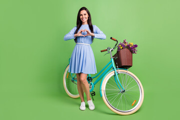 Poster - Full body photo of flirty brown hair lady show heart with bicycle wear dress isolated on green background