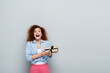 © LIGHTFIELD STUDIOS - excited woman with open mouth looking at camera while holding present on grey background