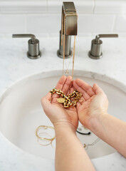 person washing hands with jewelry in the bathroom