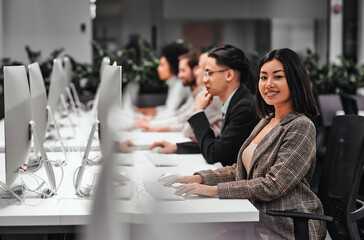 group of successful smiling business people working on computers together in a spacious office. data