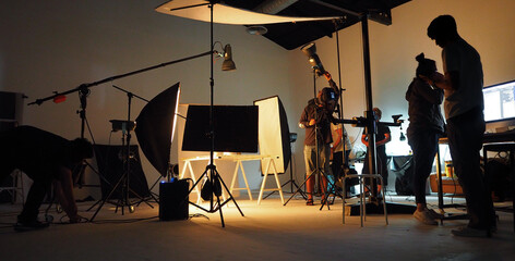 behind the shooting video production and film crew team. silhouette of people in studio setting came