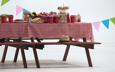 Wood table and red napkin cover for outdoor party. White background. Holiday party table. food and drink on table. studio shot.