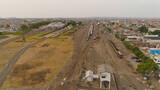 Fototapeta  - freight train with cisterns and containers on railway station Surabaya Indonesia. Wagons with goods on railroad. Heavy industry. railway station in an asian city among buildings.