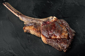 Tomahawk beef steak Grilled with spices, on black stone background