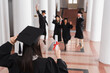 © LIGHTFIELD STUDIOS - Student holding diploma near blurred friends on blurred background in university