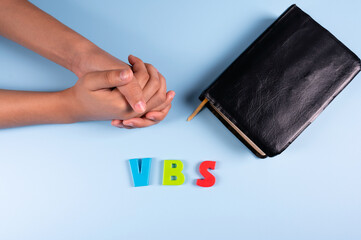 Wall Mural -  Female hands is praying next to  black bible and Abbreviation 