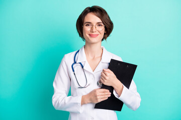 Sticker - Photo portrait of nurse smiling embracing clipboard wearing white uniform isolated vivid teal color background