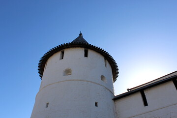 White tower of the kremlin with a wooden roof against the backdrop of a clear sky