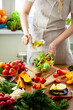© ArtSys - Beautiful young woman preparing delicious fresh vitamin salad with olive oil. Concept of clean eating, healthy food, low calories meal, dieting, self caring lifestyle. Colorful vegetables. Close up
