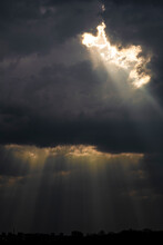 Dark Sky With Clouds, Through Which The Rays Of The Sun Break Through