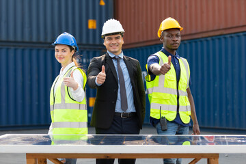 portrait factory workers or engineers thumbs up pose in containers warehouse storage