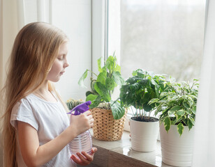 Wall Mural - Little girl splashing water on house plants