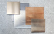 © WONGSAKORN - multi colored of hairline aluminium plate samples containg gold ,silver ,nickle silver ,copper ,black colors placed on grey stone tile. top view of interior metallic plate samples. mood tone board.