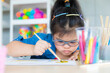 © Bangkok Click Studio - Young Asian down syndrome little girl sitting at desk with colors and painting with concentrated and calm. painting. Concept for education for disabled kid
